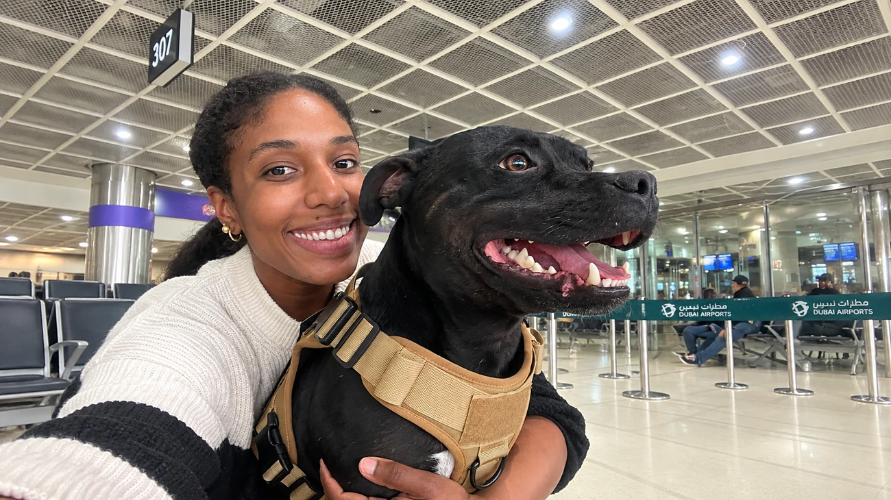 Garota abraçando carinhosamente seu cão no saguão do aeroporto de Dubai